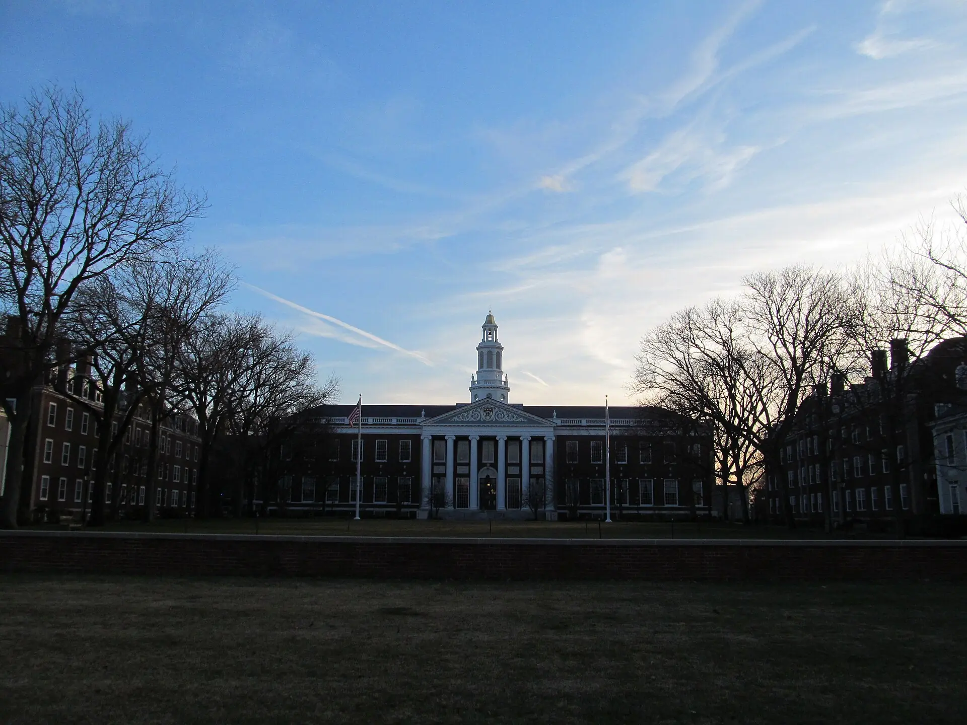 A university library building beyond bare trees