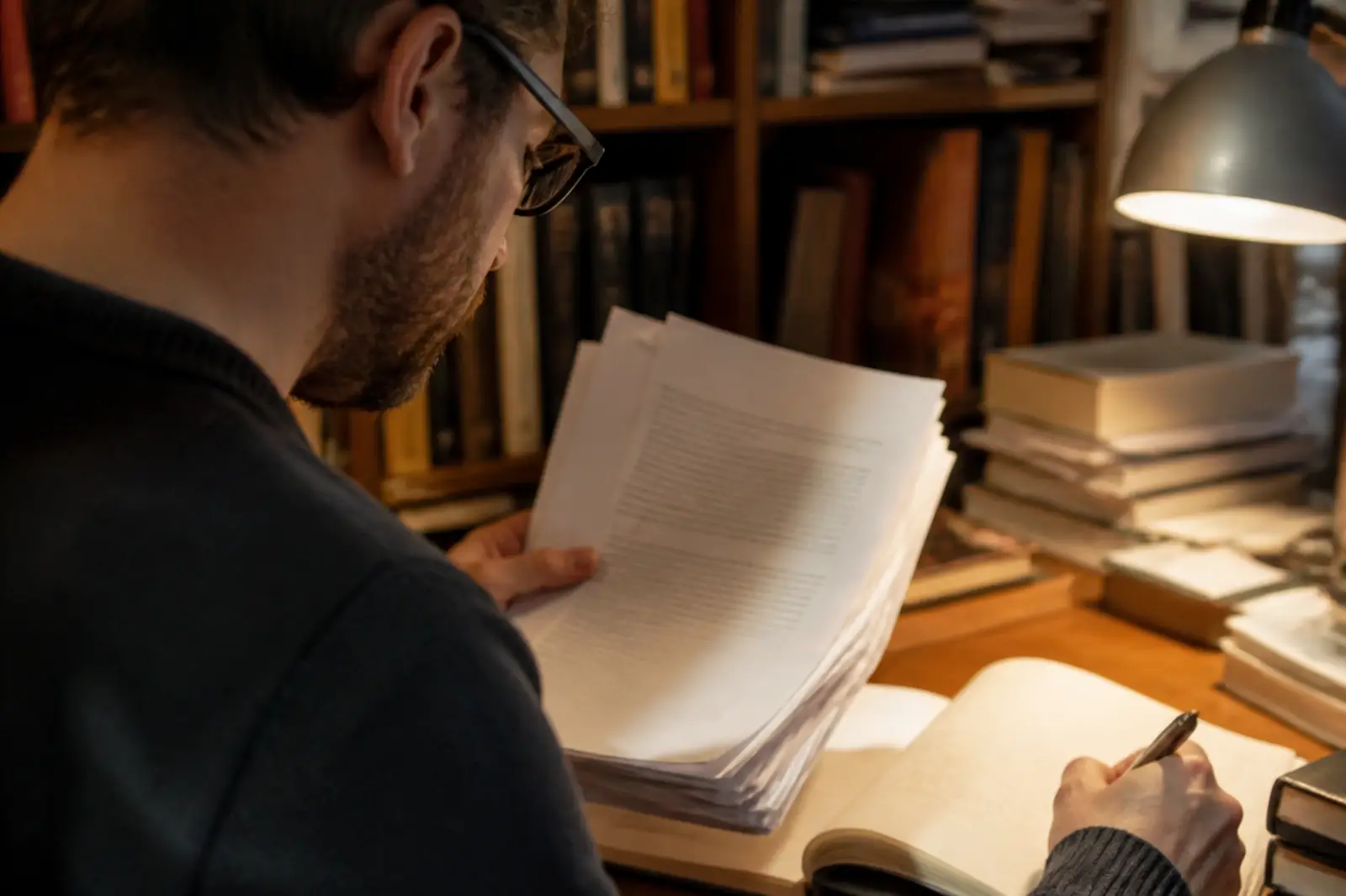 A researcher reading papers and taking notes
